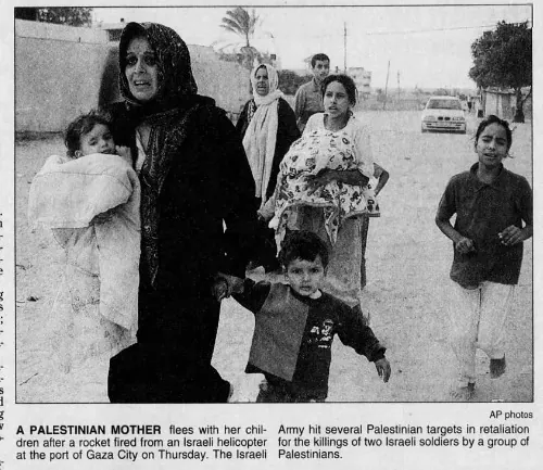 A PALESTINIAN MOTHER flees with her children after a rocket fired from an Israeli helicopter at the port of Gaza City — Florida Today, 13 October 2000