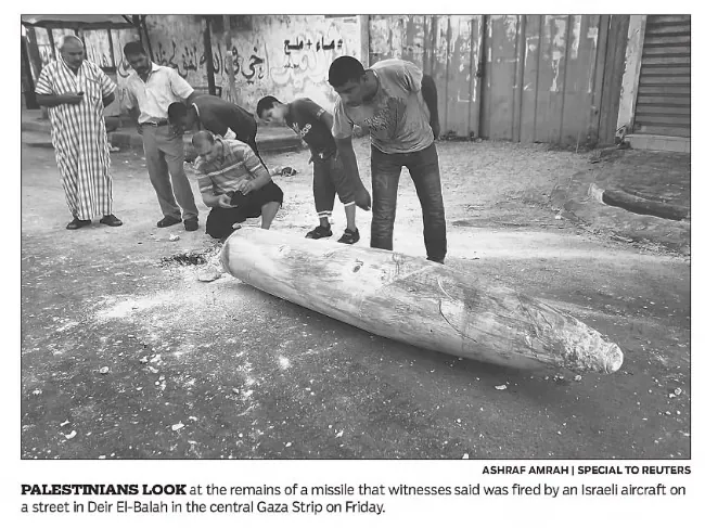 PALESTINIANS LOOK at the remains of a missile that witnesses said was fired by an Israeli aircraft on a street in Deir El-Balah — Hartford Courant, 12 July 2014