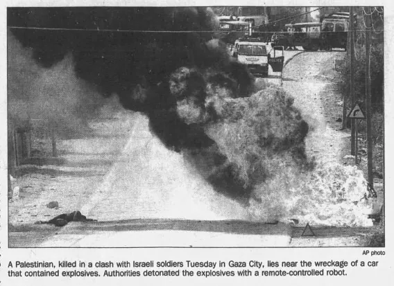 A Palestinian, killed in a clash with Israeli soldiers Tuesday in Gaza City, lies near the wreckage of a car that contained explosives &mdash; Chicago Tribune, 15 December 1993