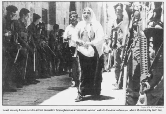 Israeli security forces monitor an East Jerusalem thoroughfare as a Palestinian woman walks to the Al-Aqsa Mosque &mdash; Wisconsin State Journal, 4 December 1988